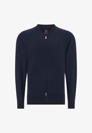 Mornarska zip-up jopica s okroglim ovratnikom, rebrastimi manšetami in dvema sprednjima žepoma. Gladka tekstura in minimalističen dizajn. Lahka tkanina.