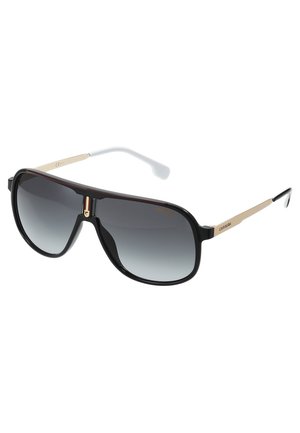 Gafas de sol con montura de plástico negra, lentes gris degradado, brazos con acentos dorados y puntas de goma blanca. Diseño angular elegante en todo.