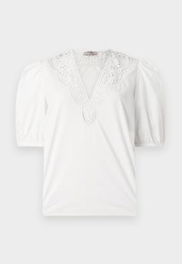 Blouse blanche avec un décolleté en V profond, ornée de dentelle délicate, des manches courtes bouffantes et un tissu lisse et texturé.
