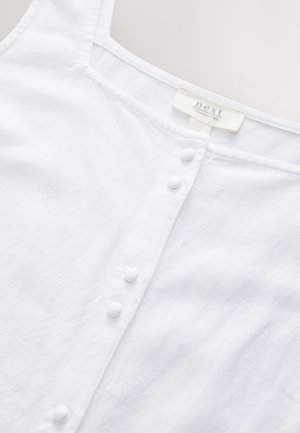 Hvid linnedtop med firkantet halsudskæring, med knapstykke med hvide knapper og et subtilt tekstureret stof. Mærkeetiket synlig.