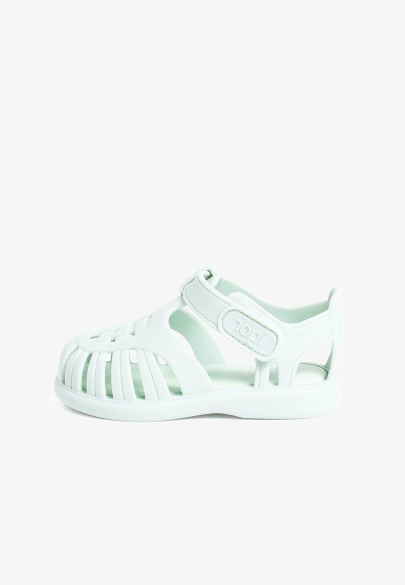 Light green plastic sandal with open design, adjustable strap, and cut-out details for ventilation. Lightweight and flexible construction.