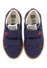 Zapatillas de lona navy con dos tiras de Velcro, suela de goma texturizada y acentos rojos. Cuenta con plantillas de espuma con memoria para mayor comodidad.