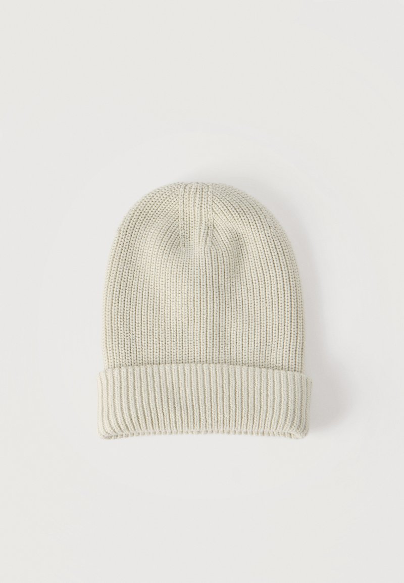 Μπεζ σκουφάκι από πλεκτό ριμπ ύφασμα με διπλωμένο γείσο, τοποθετημένο επίπεδα σε λευκό φόντο.