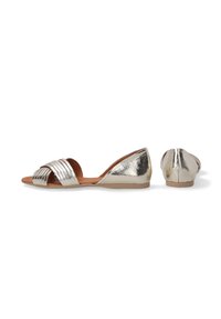 Metallisch zilveren platte sandalen met een geweven bandontwerp, open teen en een zachte textuur. Voorzien van een lage hak en een bruine binnenzool.