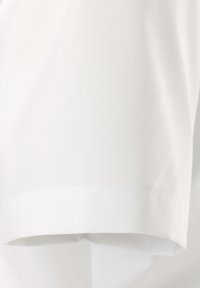 Wit katoen stof met een gladde textuur, met een schone zoom en nauwkeurige stiksels langs de rand. Geen patronen of accenten aanwezig.