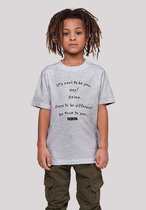 Grau Baumwoll-T-Shirt mit kurzen Ärmeln, das schwarzen Text mit motivierenden Sprüchen zeigt. Getragen mit grünen Cargo-Hosen.