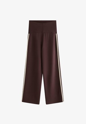 Bredde bukser i mørkebrun farve med høj talje og hvide sidelister, fremstillet mod en ensfarvet hvid baggrund.