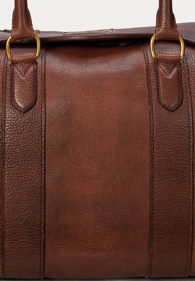 Brązowa torebka ze skóry o fakturze, z podwójnymi uchwytami przymocowanymi złotymi pierścieniami, z widocznym przeszyciem, bez widocznych logo ani wzorów.