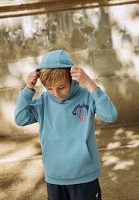 Blauer Kapuzenpullover aus Baumwollmischung, mit einer Fronttasche, gerippten Bündchen und einer "Cool Vibes"-Grafik mit einem Smiley.