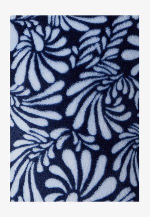 Tissu bleu marine avec un motif floral blanc comprenant des feuilles tourbillonnantes. Texture douce avec des motifs détaillés et répétitifs, créant un effet visuel dynamique.