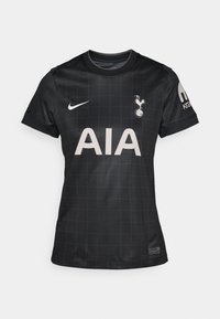 Maillot de football noir avec un motif en grille, présentant un col rond, des manches courtes et les logos de Nike et de Tottenham Hotspur.