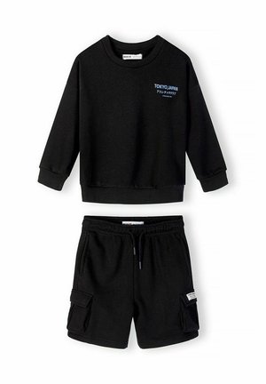 Sort todelt sæt med en langærmet sweatshirt med teksten "Tokyo, Japan" og matchende cargoshorts med lommer og snøre i taljen.