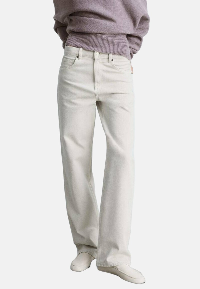 Jeans din denim alb cu croială dreaptă, design cu cinci buzunare și detalii de cusătură subtile. Asortate cu un pulover tricotat de un violet deschis.