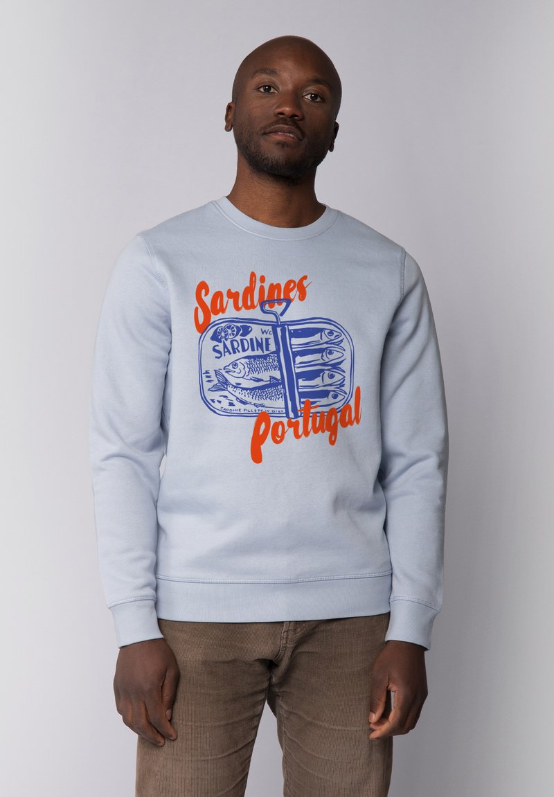 Sweatshirt bleu clair avec un graphique d'une boîte de sardines et du texte orange et bleu indiquant "Sardines Portugal." Tissu doux, design col rond.