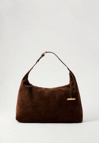 Rudos spalvos zomšinė rankinė su apvalia forma, vienu rankena ir auksinės spalvos metaliniu akcentu prisegtu prie dirželio. Visas paviršius lygus.