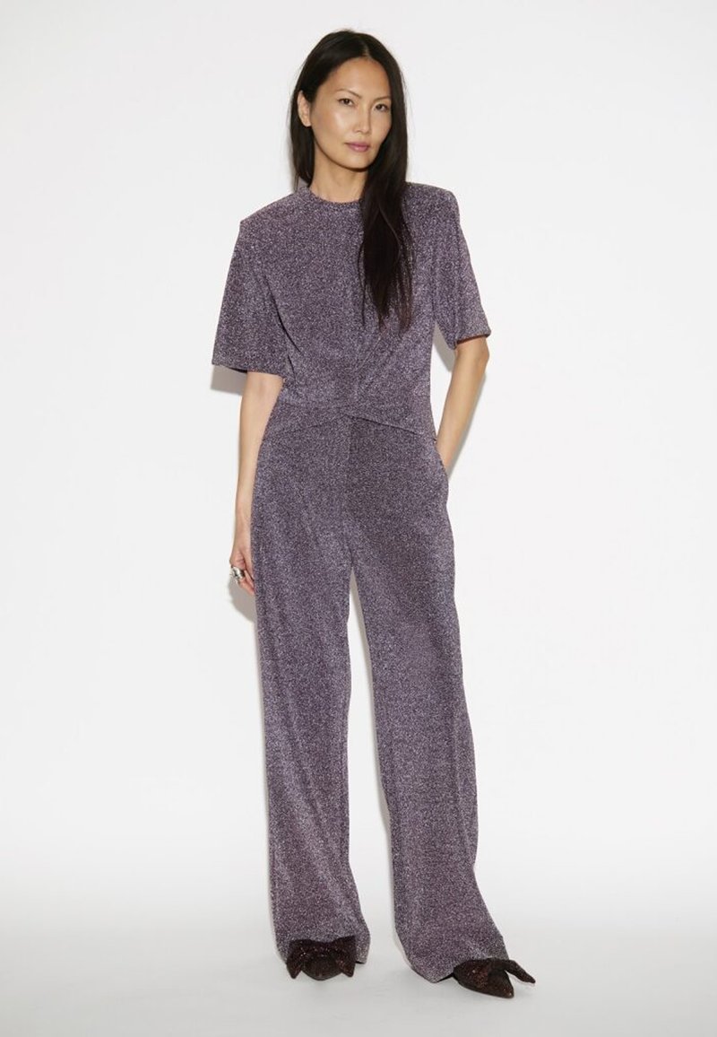 Paarse metalen jumpsuit met korte mouwen, gestructureerde stof, wijde pijpen en een nauwsluitende taille. Voorzien van een subtiele glans en een gladde afwerking.