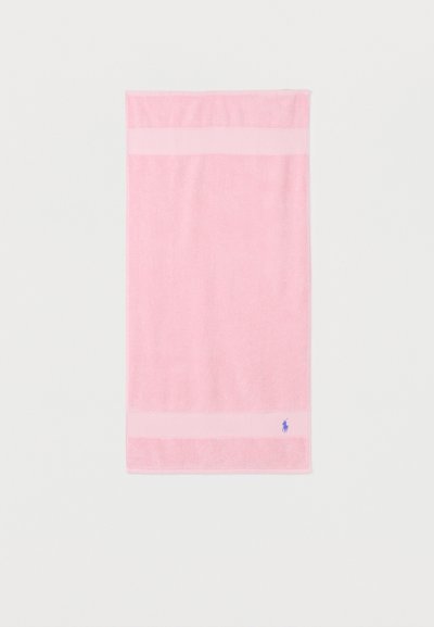 Ροζ ορθογώνια πετσέτα με δύο ανοιχτόχρωμες οριζόντιες ρίγες και ένα μικρό μπλε λογότυπο αλόγου στην κάτω δεξιά γωνία.
