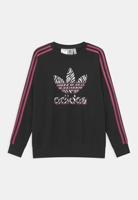 Sweat-shirt noir avec des rayures roses sur les épaules, un logo Adidas à motif zèbre sur le devant, et des poignets et un ourlet côtelés.