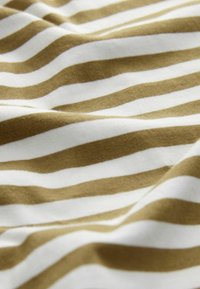 Puuvillakangas, jossa on vaaleanbeigejä ja valkoisia vaakasuoria raitoja. Pehmeä rakenne, jossa on hieman joustoa ja rento laskeutuminen.