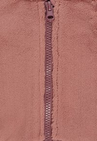 Fleece jacket in dusty rose with a vertical zipper, featuring soft texture, a smooth finish, and minimal seam detailing.