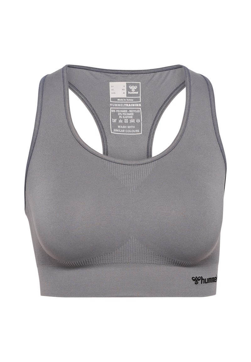Szary, bezszwowy stanik sportowy typu racerback z logo hummel na dolnym prawym rogu oraz metką z rozmiarem i instrukcją pielęgnacji wewnątrz tylnej części.