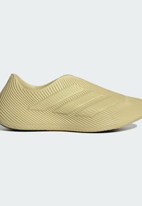 Pantof sport galben cu suprafață nervurată, design elegant, cu trei dungi în relief și o siluetă rotunjită, fără cusături.