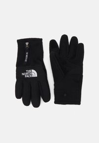 Sorte handsker lavet af blødt fleece-materiale med en lynlåslukning ved håndleddet. Funktioner inkluderer struktureret greb på håndfladen og hvidt logo på håndleddet.