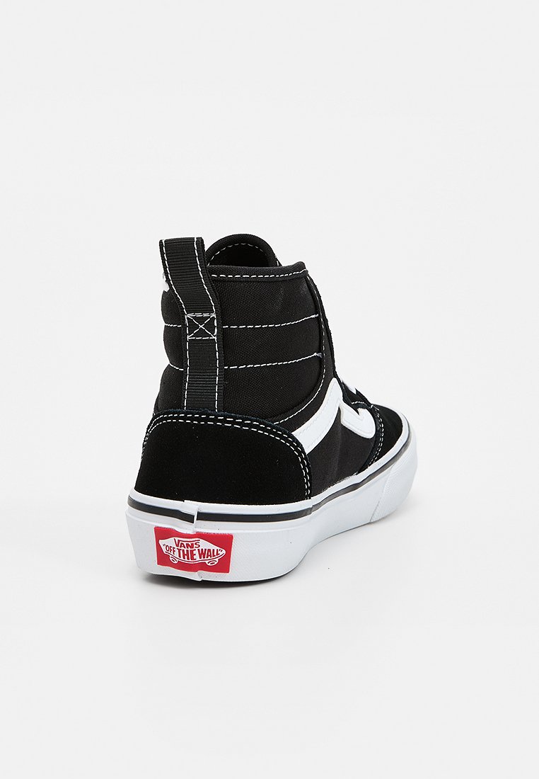 Zapatilla deportiva de ante negro de caña alta con acentos blancos, cuello acolchado, costuras contrastantes y suela de goma con un logo rojo de Vans en la parte trasera.