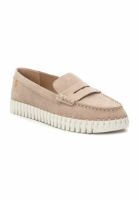 Mocasines de ante beige claro con una suela de goma blanca baja, que presentan un diseño cosido, una ranura para monedas y un pequeño logo como acento en el lateral.