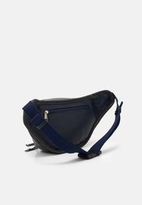Svart läder midjeväska med ett marinblått band, rundad form, framficka med dragkedja och diskret textur. Lämplig för avslappnad stil och funktionalitet.