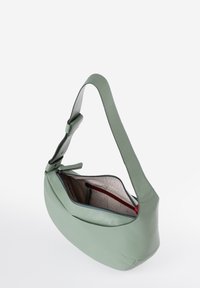Borsa a spalla verde in pelle con una tracolla ampia, apertura con zip e una tasca interna rossa. Texture liscia e forma rotonda.