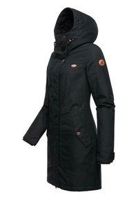 Svart parka med hette, med glidelås og knappelukk, sidelommer og lærdetalj på ermet. Strukturert stoff.