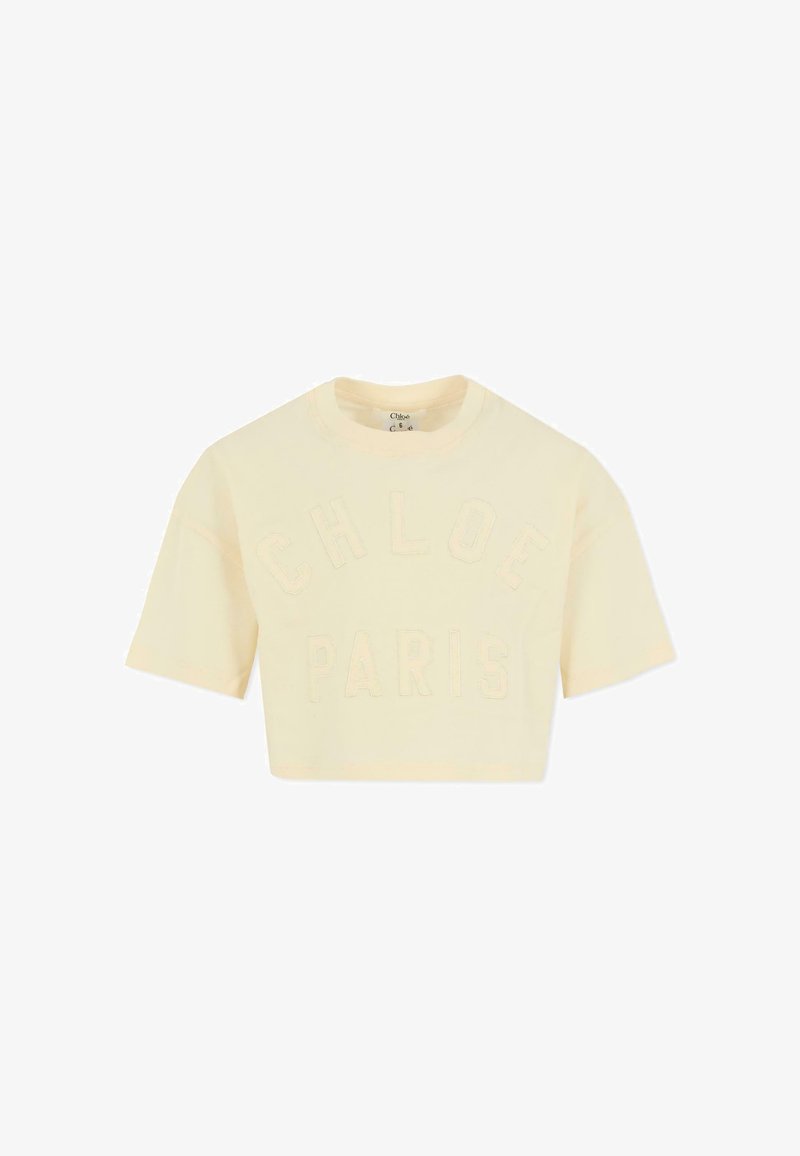 Krótka koszulka w kolorze kremowym, wykonana z miękkiej bawełny, z wytłoczonym napisem "CHLOE" i "PARIS" na przodzie. Krótkie rękawy, okrągły dekolt.