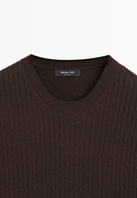 Pull en maille torsadée brun foncé avec col rond et étiquette de marque Massimo Dutti à l’intérieur du col.
