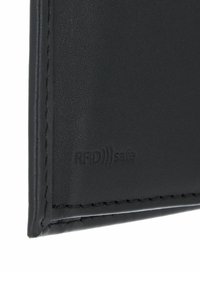Black leather wallet close-up showing smooth texture, rectangular shape, and embossed "RFID safe" detail near the edge.