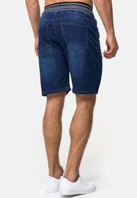 Denim šortsevi u tamnoplavoj boji s opuštenim krojem, s pojasom od elastina, dizajnom s pet džepova i suptilnim šavovima.