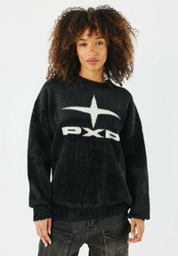 Schwarzer, flauschiger Pullover mit einem weißen Logo "PXP" in der Mitte und einem abstrakten Stern-Design. Hat lange Ärmel und eine lockere Passform.