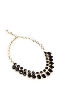 Złota naszyjnik z czarnymi prostokątnymi i okrągłymi kamieniami w zakrzywionym układzie, z detalem łańcuszka i regulowanym zapięciem.