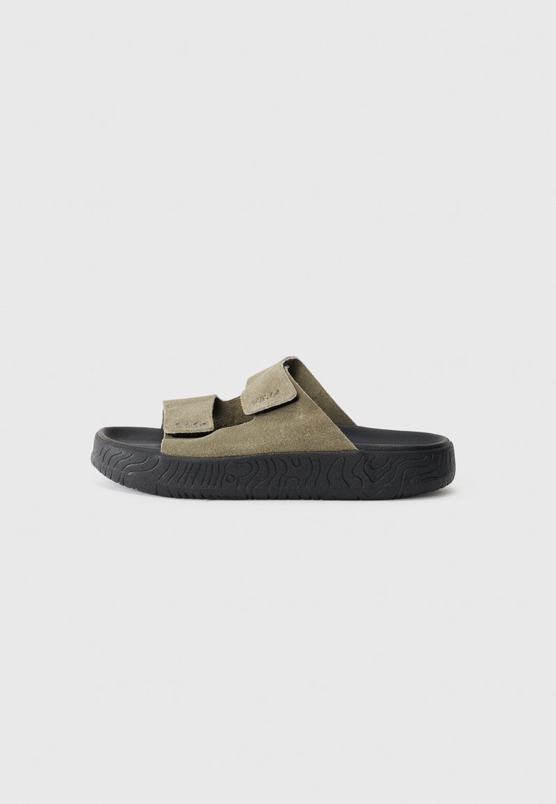Olive green suede slide sandals with two adjustable hook-and-loop straps. Black textured rubber outsole for traction and durability.