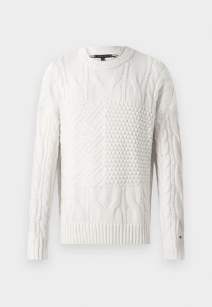 Λευκό πουλόβερ με πλέξη κασμίρ, με διάφορες υφαντικές υφές, στρογγυλή λαιμόκοψη, και  ribbed μανσέτες και στρίφωμα. Λείο φινίρισμα με μονόχρωμο σχέδιο.