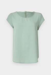 Blouse vert clair à manches courtes avec un col rond et une fermeture éclair au dos. Tissu lisse avec une coupe légèrement décontractée. Design simple et moderne.