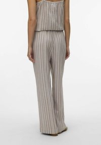 Pantalons en tissu léger à rayures avec une coupe décontractée, présentant des lignes verticales dans des tons de beige doux et de rose atténué. Design de jambes évasées.