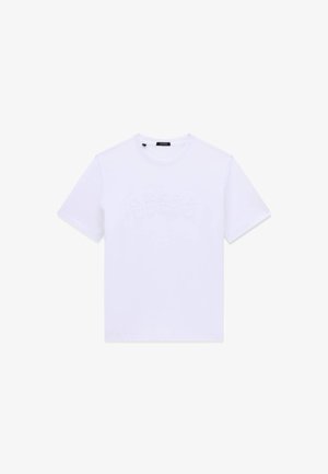 Biała koszulka z krótkim rękawem i okrągłym dekoltem z subtelnym, wytłoczonym logo "GUESS" na piersi, przedstawiona na jednolitym białym tle.