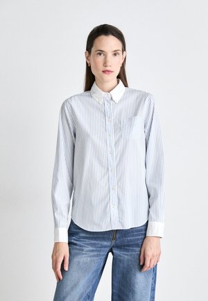 Button-up shirt with blue and white vertical stripes, featuring a white collar, cuffed sleeves, and a chest pocket. Cotton fabric.
