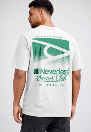Man with short curly hair wearing white t-shirt with green geometric design and "Neverless Soccer Club" text on back, facing sideways.