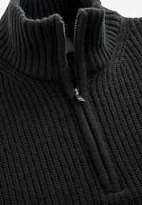 Schwarzer Strickpullover mit hohem Kragen, halb durchgehendem Reißverschluss, strukturiertem Rippdesign und weichem, dickem Stoff für zusätzliche Wärme.