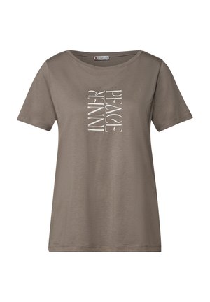 Tričko s krátkým rukávem a volným střihem v tlumené hnědé barvě. Na přední straně je vertikální bílý text: „VNITŘNÍ MÍR." Vyrobeno z měkké bavlny.