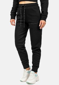 Zwarte katoenen sweatpants met elastische boorden en een trekkoord in de taille, met zijzakken en subtiele logo-embroidery op het been.