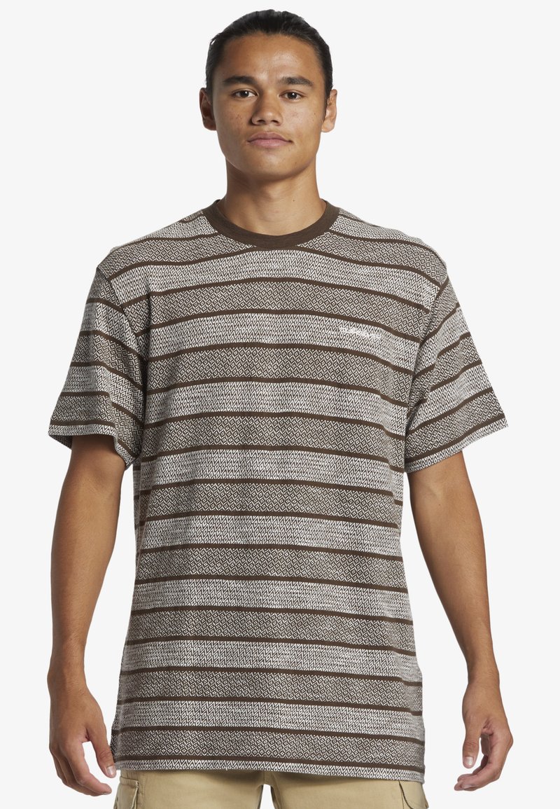 Bruin en crème gestreepte t-shirt met korte mouwen, voorzien van een geometrisch patroon en een ronde halslijn. De stof lijkt textuur te hebben en is licht van gewicht.