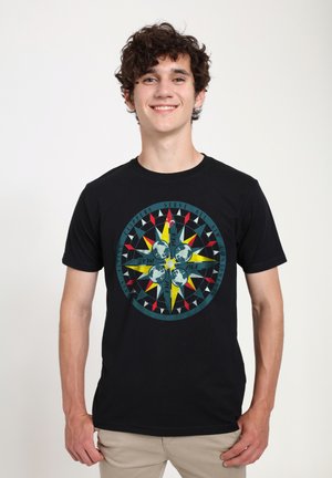 Sort kortærmet t-shirt med et farverigt kompasmotiv, der har tre kloder, gule accenter og røde trekantede mønstre.